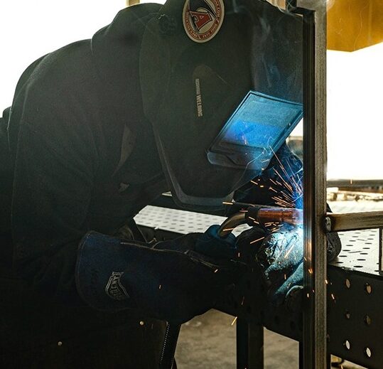 A man welding something on top of a table.