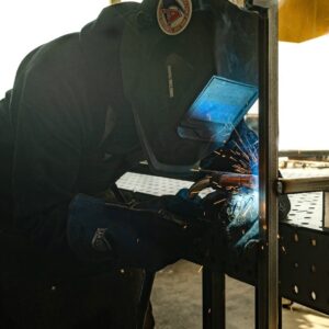 A man welding something on top of a table.