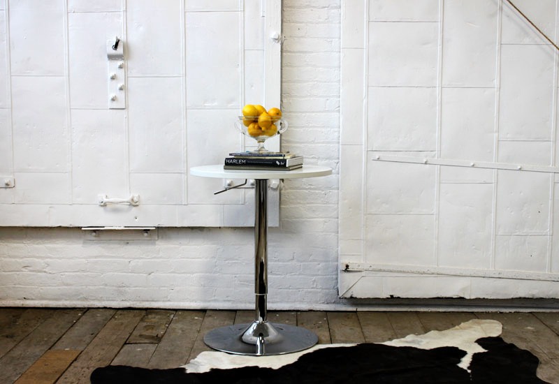 A table with a vase of lemons on top