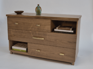 A wooden dresser with drawers and shelves on top.