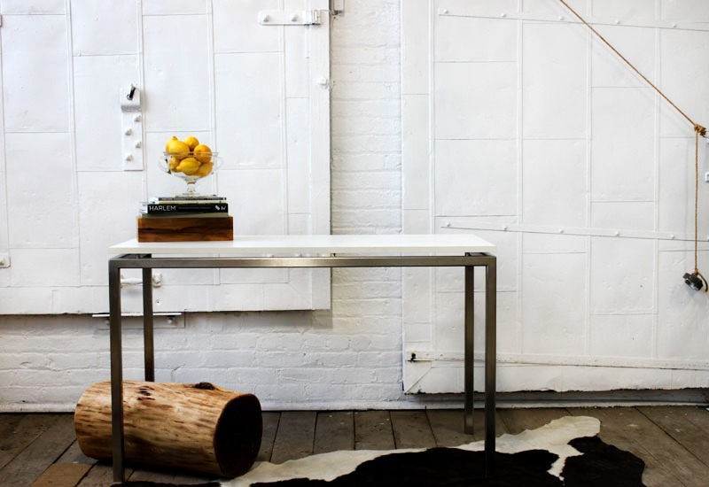 A table with a white top and wooden legs.