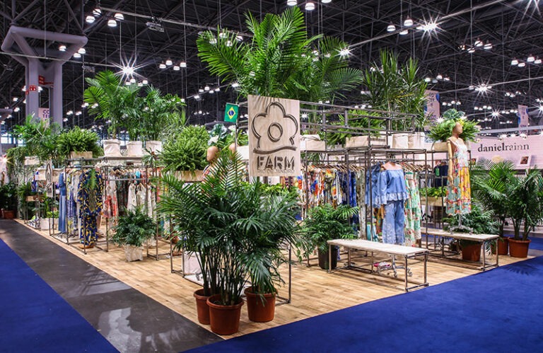 A room with plants and clothing on display.