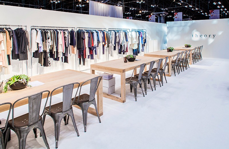 A long table with chairs in front of a wall.