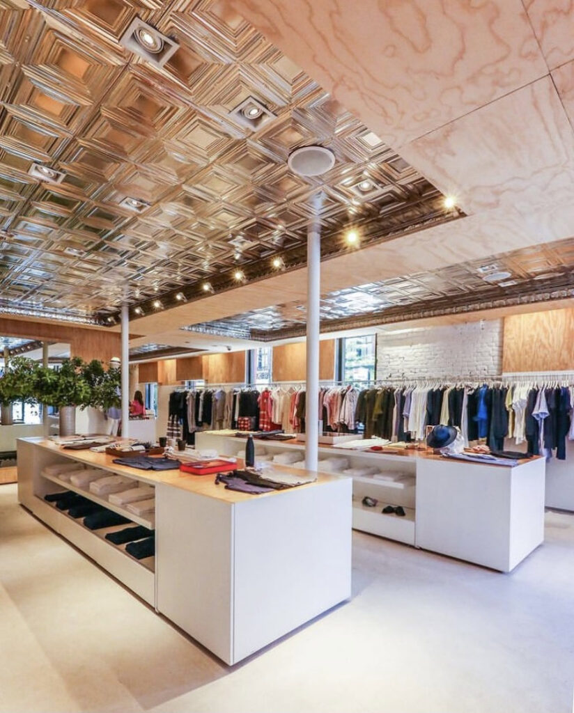 Modern clothing store interior with tiled ceiling.