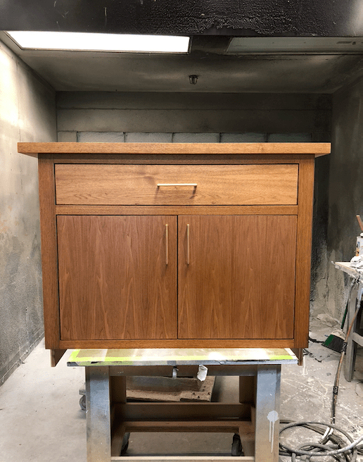 A wooden dresser with gold knobs and handles.