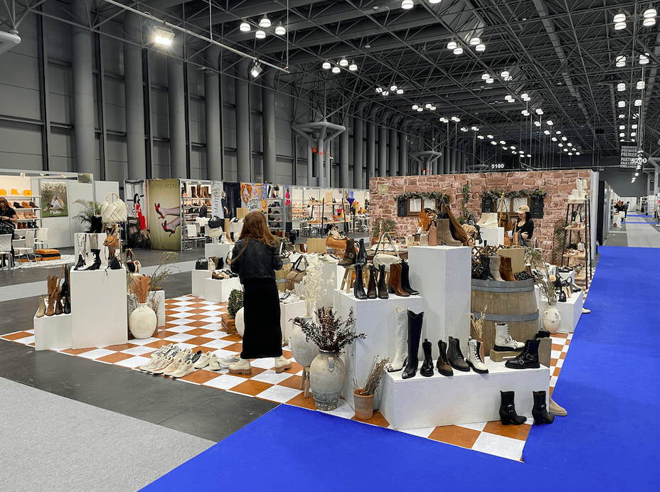 A woman standing in front of several stands with shoes on them.