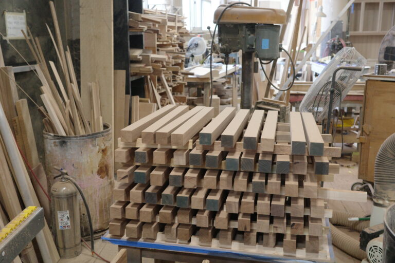 A pile of wood in a room with many other wooden items.