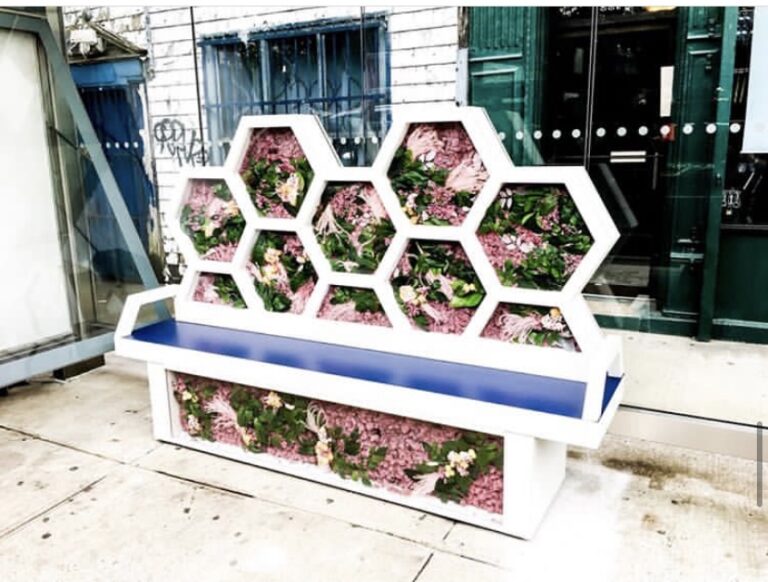 A bench with flowers on it sitting outside.