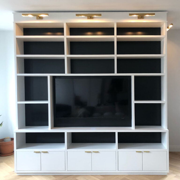 A large white entertainment center with a flat screen tv mounted on it.