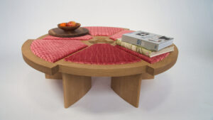 A wooden table with red leather seats and books on top.