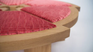A close up of the red seat cushion on a wooden table.