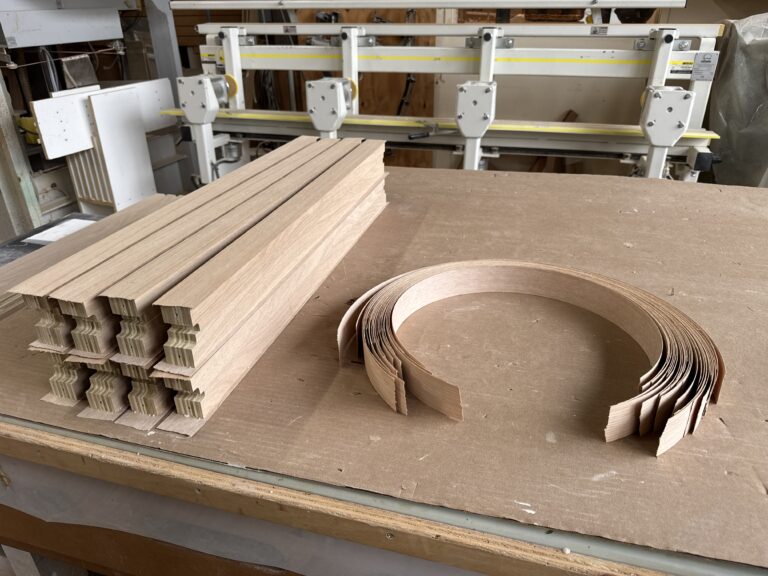 White oak edge band being applied to parts